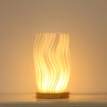 3D printed cylindrical vase night lamp in wood colour finish on a modern bedside table