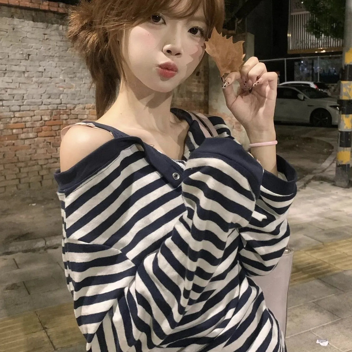 Dark blue oversized women's long-sleeve t-shirt with stripes, button detail, and embroidery on the front.