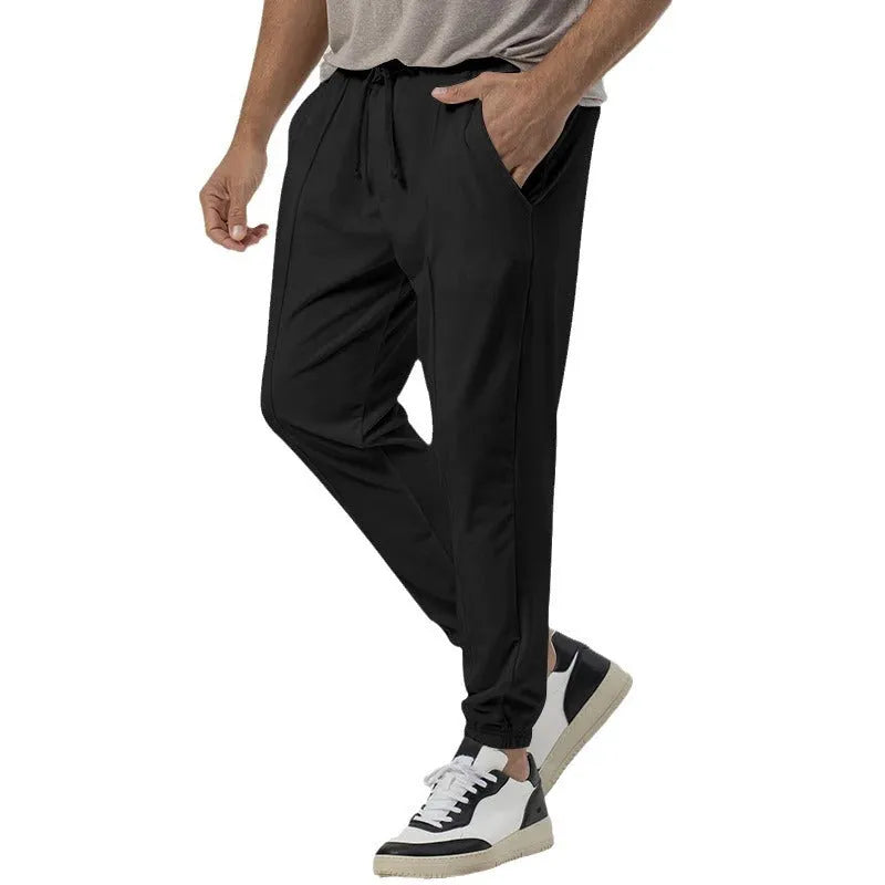 Men's grey loose tapered track sweatpants with elastic waist and straight leg design.
