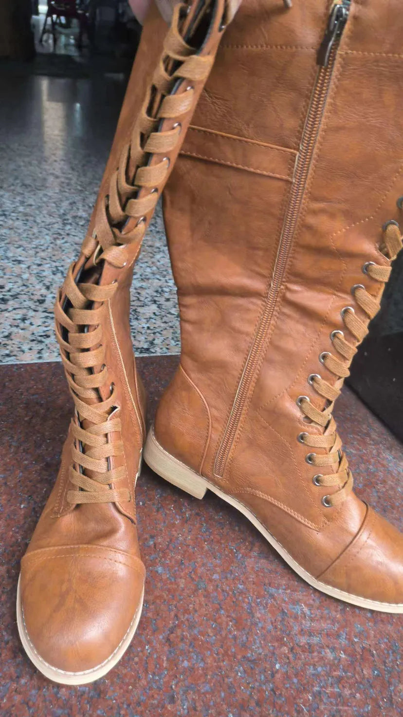 Women's black cross-strap knight boots made from artificial PU, side view.