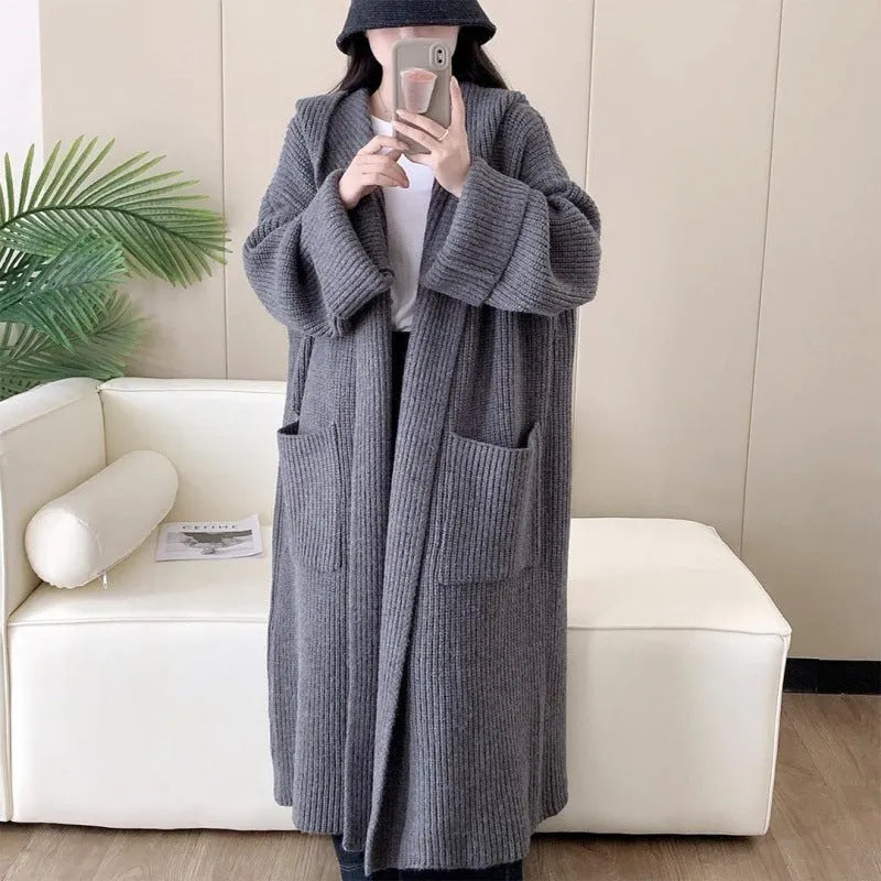 Women's loose grey hooded cardigan coat with raglan sleeves on a hanger