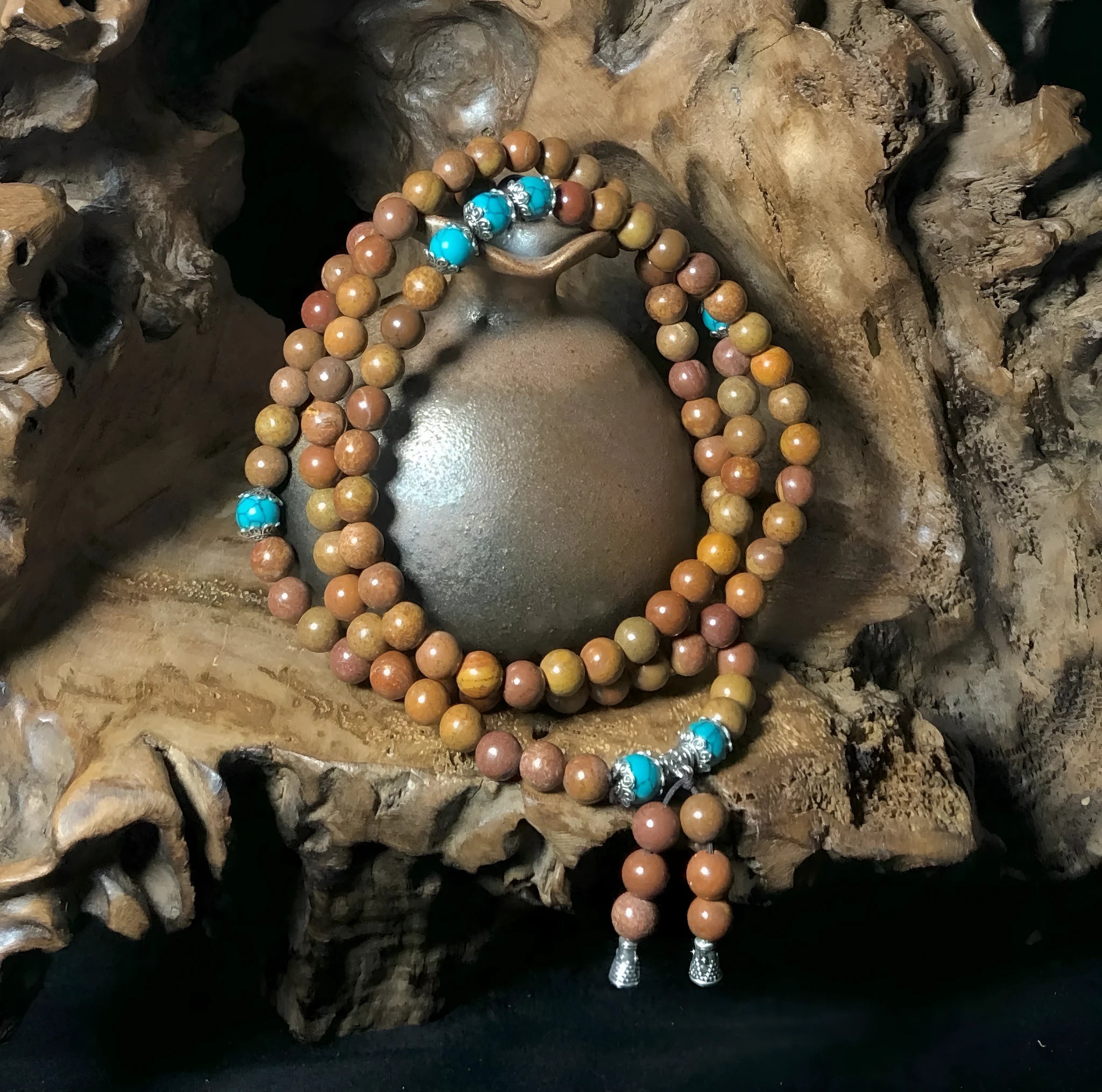 Handmade geometric bracelet with 108 smooth Lvzhu stone beads.