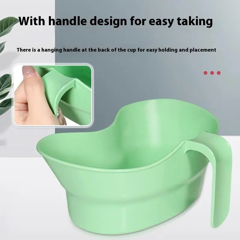 Green plastic nursing cup with an angled spout for bedridden patient drinking.