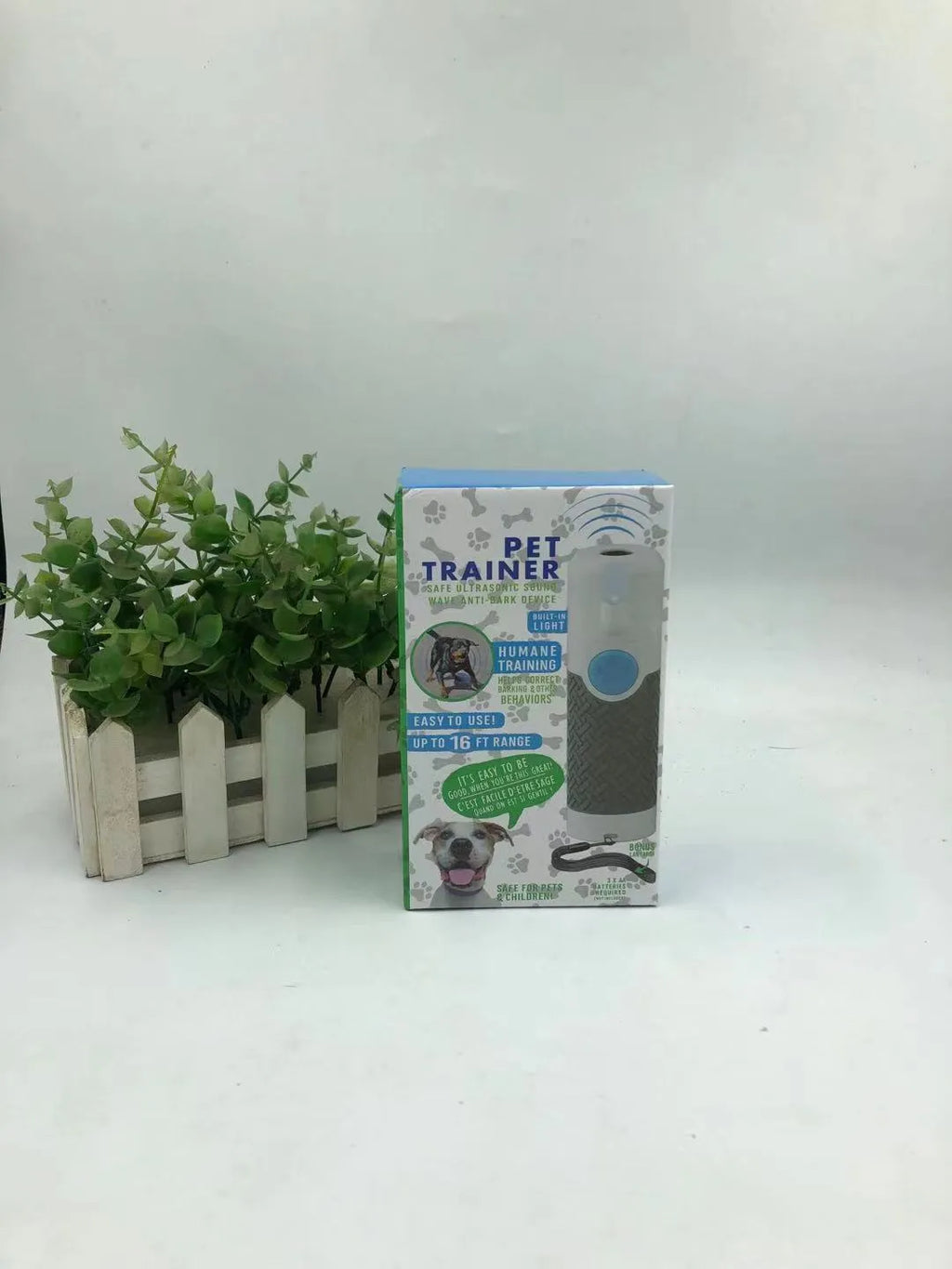 White handheld ultrasonic dog bark control trainer unit on a white background.