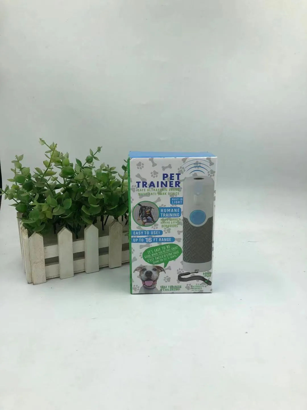 White handheld ultrasonic dog bark control trainer unit on a white background.
