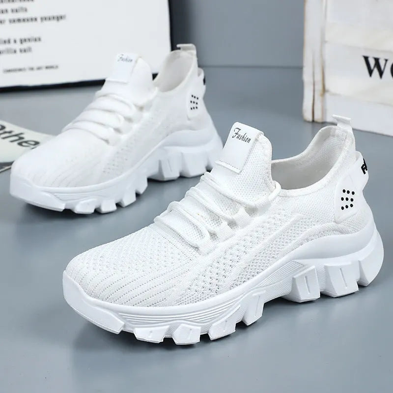 Women's white Flyknit running sneaker with thick PVC sole and lace-up front on a neutral background.
