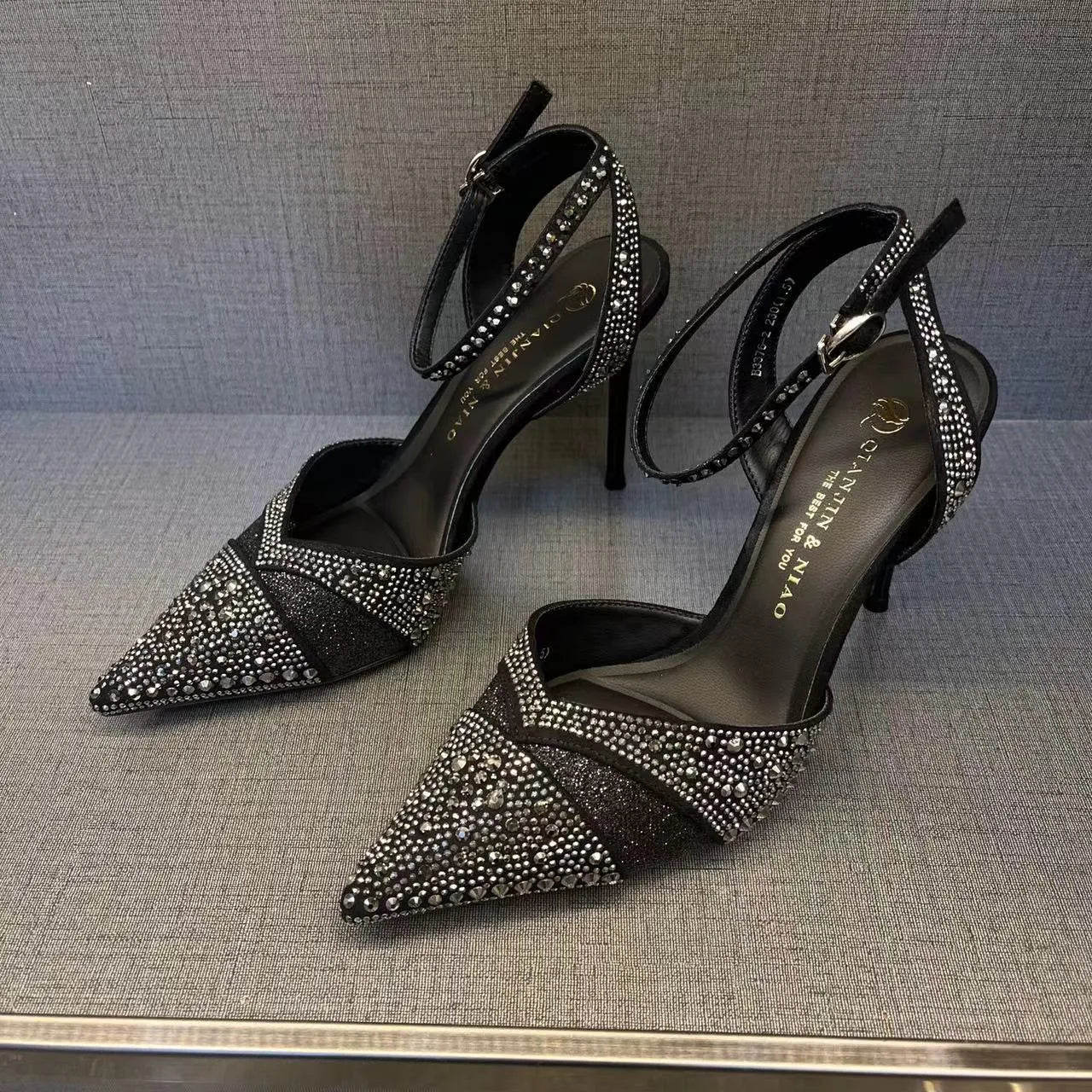 Women's black stiletto high heels with red sole and pointed toe design