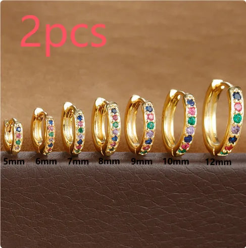 Set of gold, rose gold, and silver perforated circle stud earrings in multiple sizes on a flat surface.