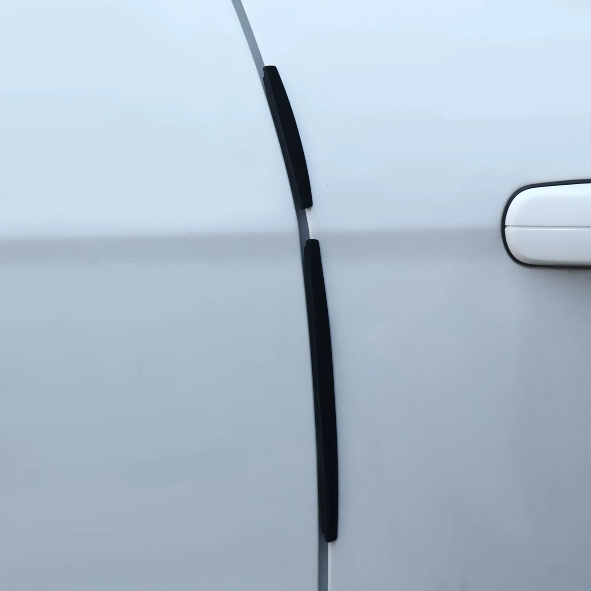 White plastic car door edge anti-collision bumper strip on a vehicle door