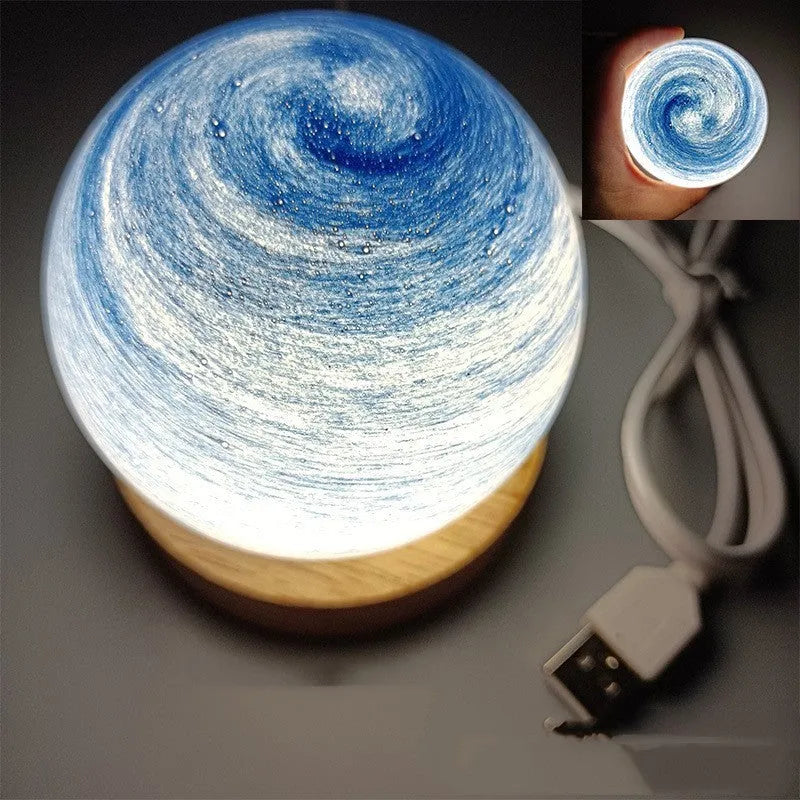 Planet night light with spherical design on base, USB cable connected, showing adjustable three-colour lighting
