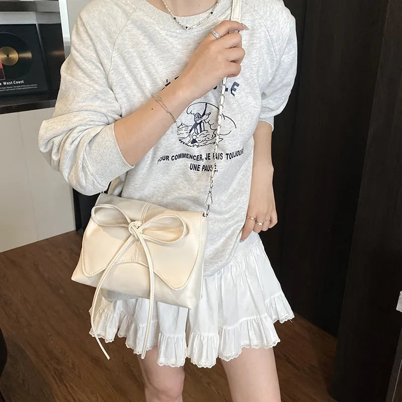 Women's black PU leather crossbody bag with horizontal square shape and visible sewing details