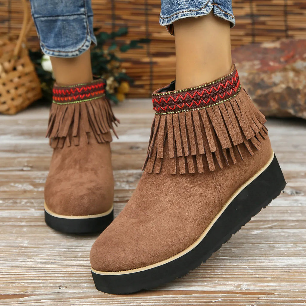 Women's black suede wedge ankle boot with side zip and tassel detail on a thick rubber platform sole.