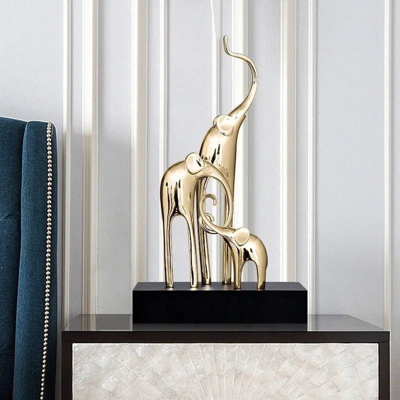 Detailed resin elephant figurine ornament in metallic gold finish on a wooden shelf.