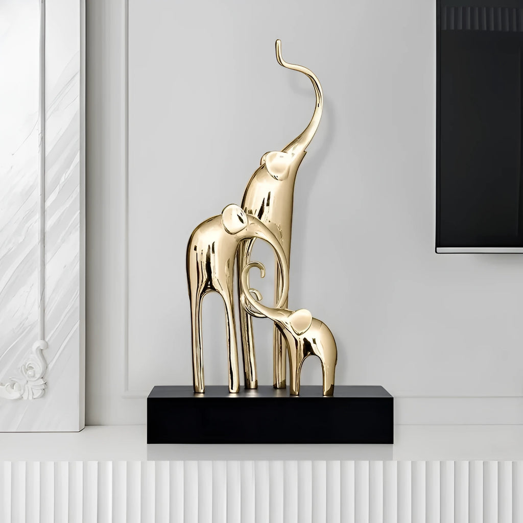 Detailed resin elephant figurine ornament in metallic gold finish on a wooden shelf.