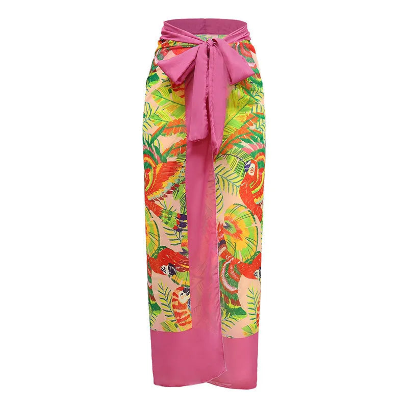 Pink floral print women's one-piece swimsuit with V-neck and matching skirt on beach