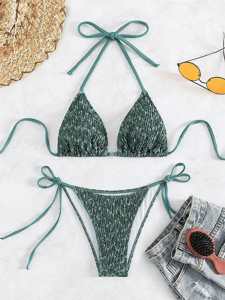 Women's green halter strap backless swimsuit top with matching shorts on hanger