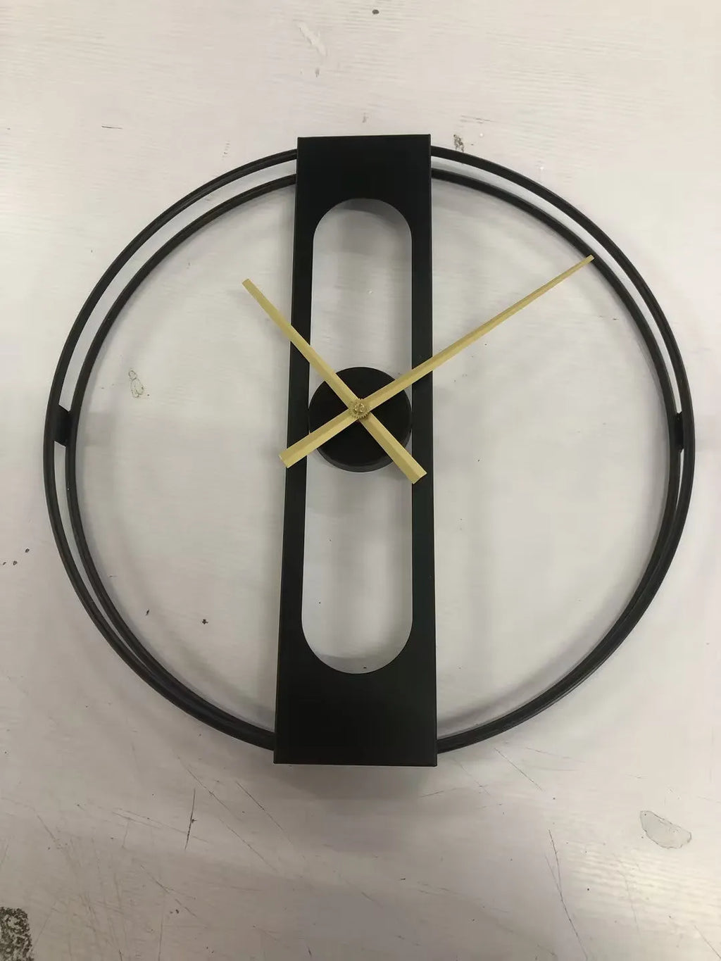 Large round metal wall clock with a 50cm diameter in a black finish on a white wall.