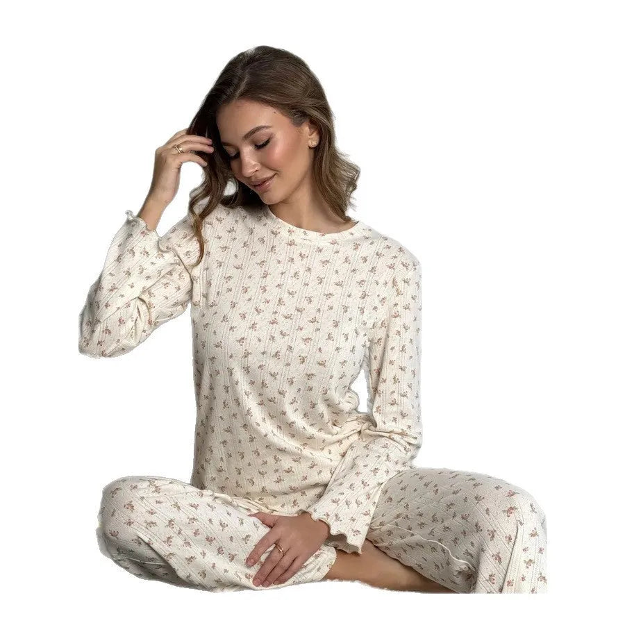 Women's white floral print suit set featuring a round neck top with bell sleeves and wide leg trousers.