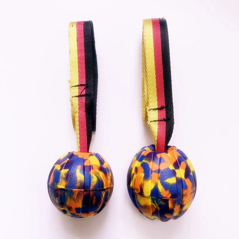 Camouflage and yellow EVA foam floating dog training balls in three different sizes on a blue background.