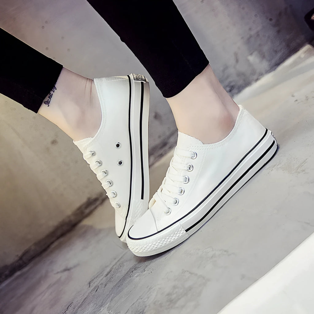 Solid colour women's canvas lace-up flats in black, shown on a white background.