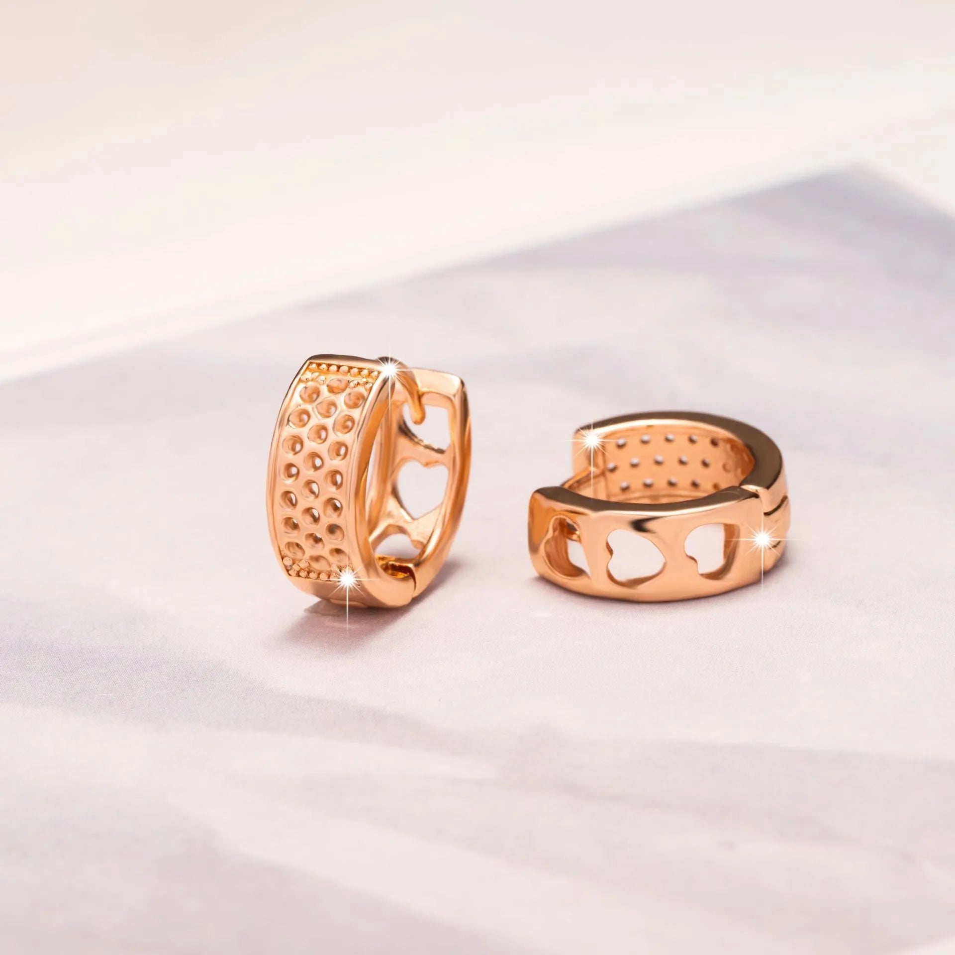 Rose gold hollow heart earrings with circular design and electroplated finish