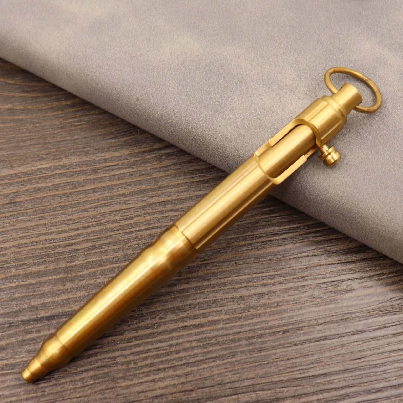 Retro brass tactical pen with cylindrical barrel and six-ring grip, shown with press mechanism extended