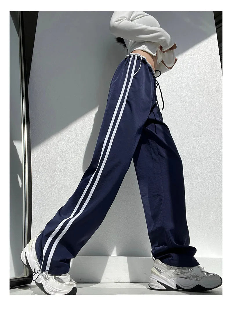 Navy blue loose straight-leg trousers with contrast ribbon trim and a slimming drape