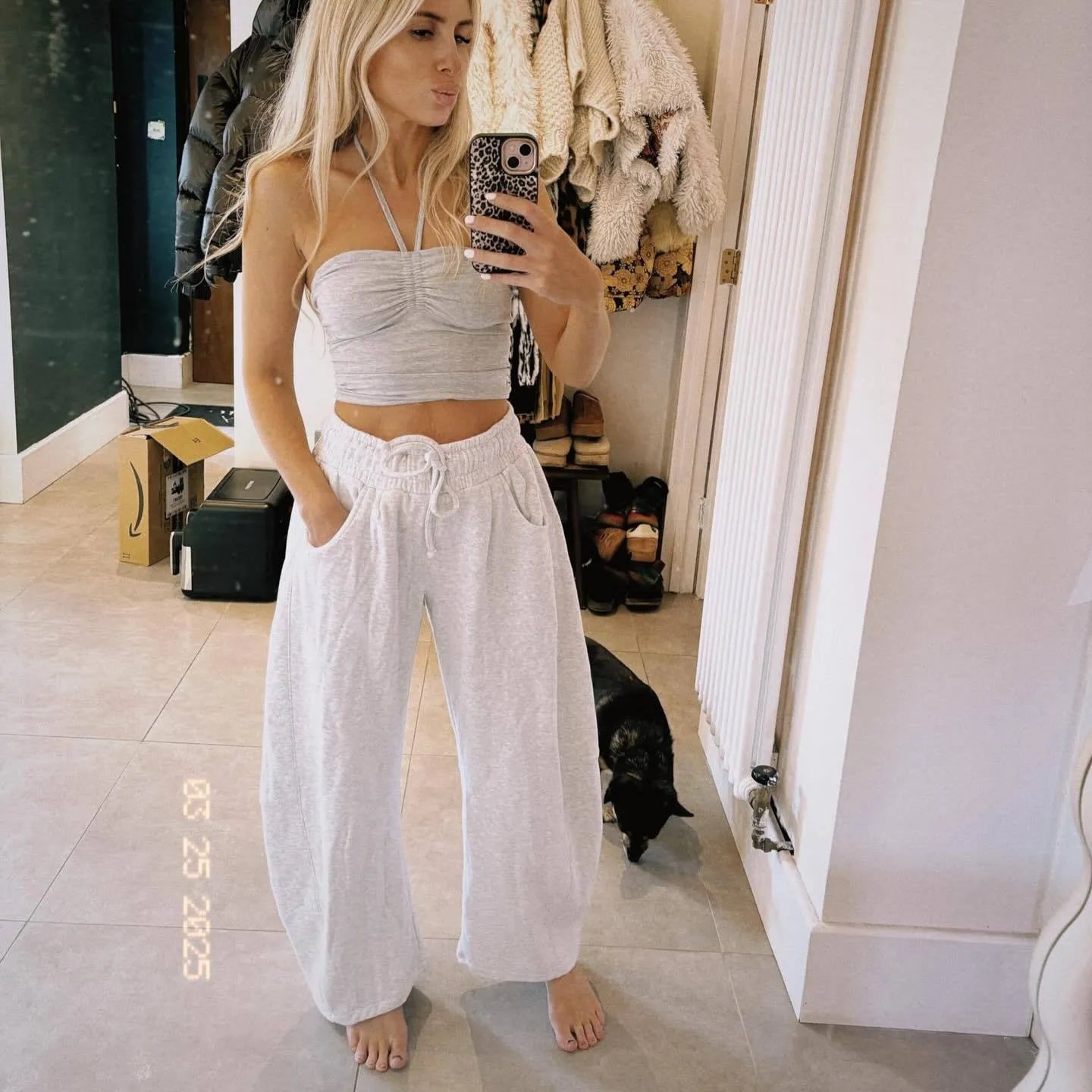 Loose grey cropped sweatpants with elastic drawstring waist and pockets on a mannequin
