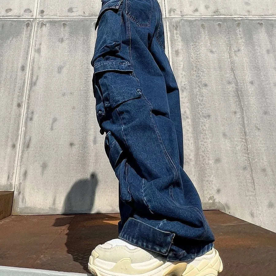 Dark blue distressed wide-leg high-waist jeans with multiple pockets on a denim background.