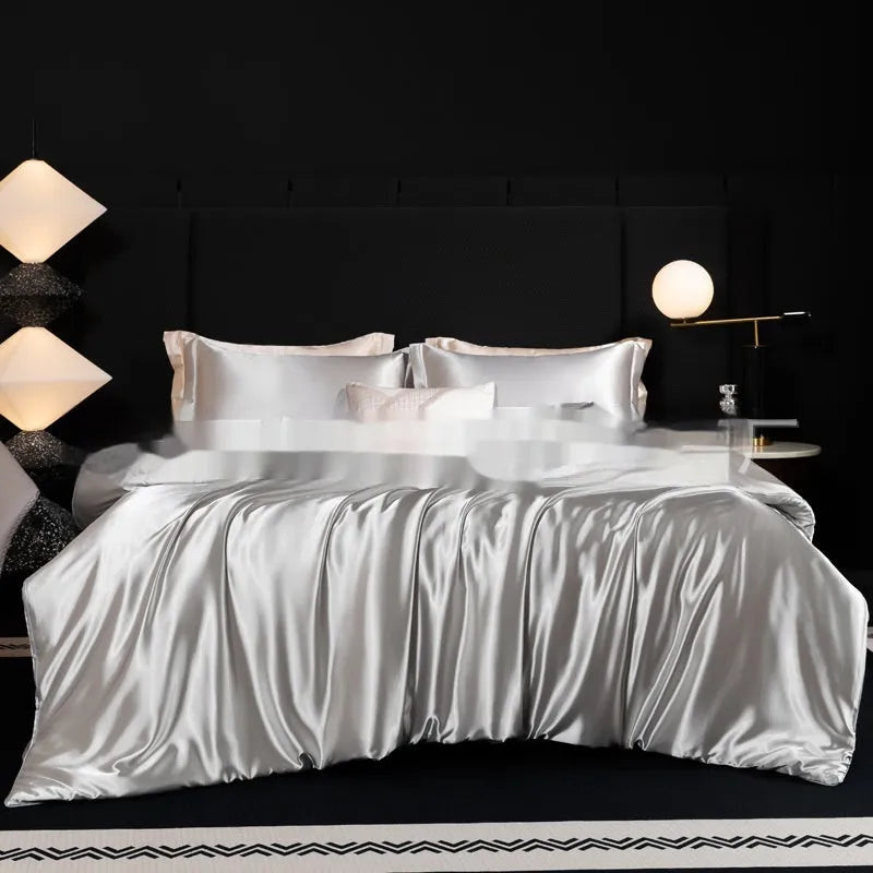 Silk bed sheet four-piece set in solid colour folded, showing options for Ash Purple, Cool Black, and Golden Camel.