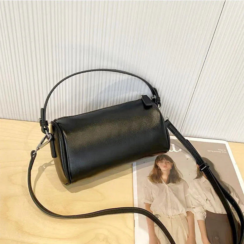 Soft genuine leather cylindrical crossbody phone bag in brown with a single shoulder strap.