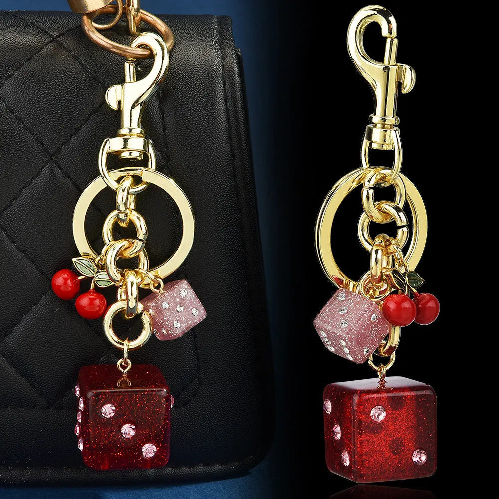 Vintage cherry two-tone square metal dice bag keychain pendant on a keyring.