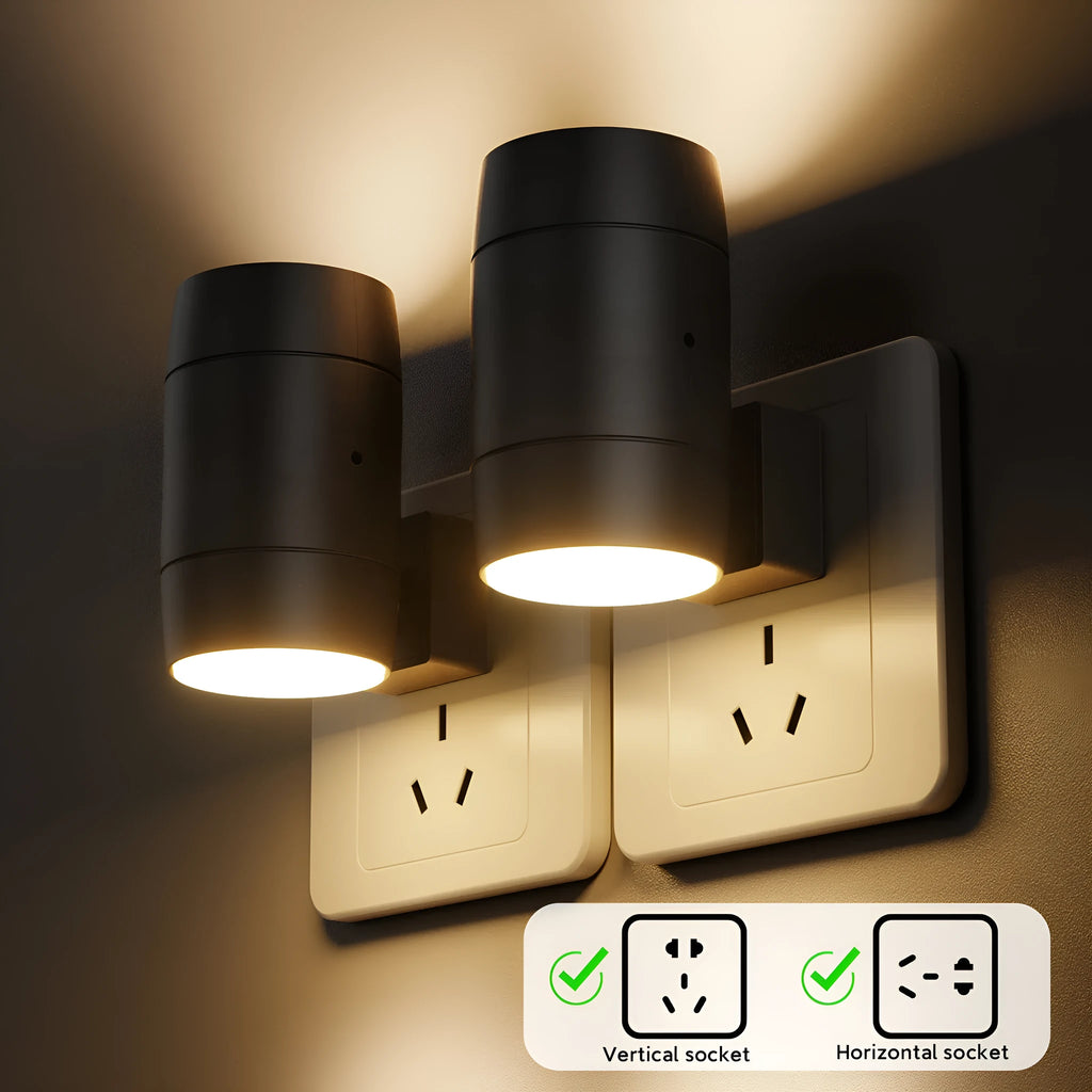 A compact white plug-in night lamp with a rotatable head, shown plugged into a wall socket.