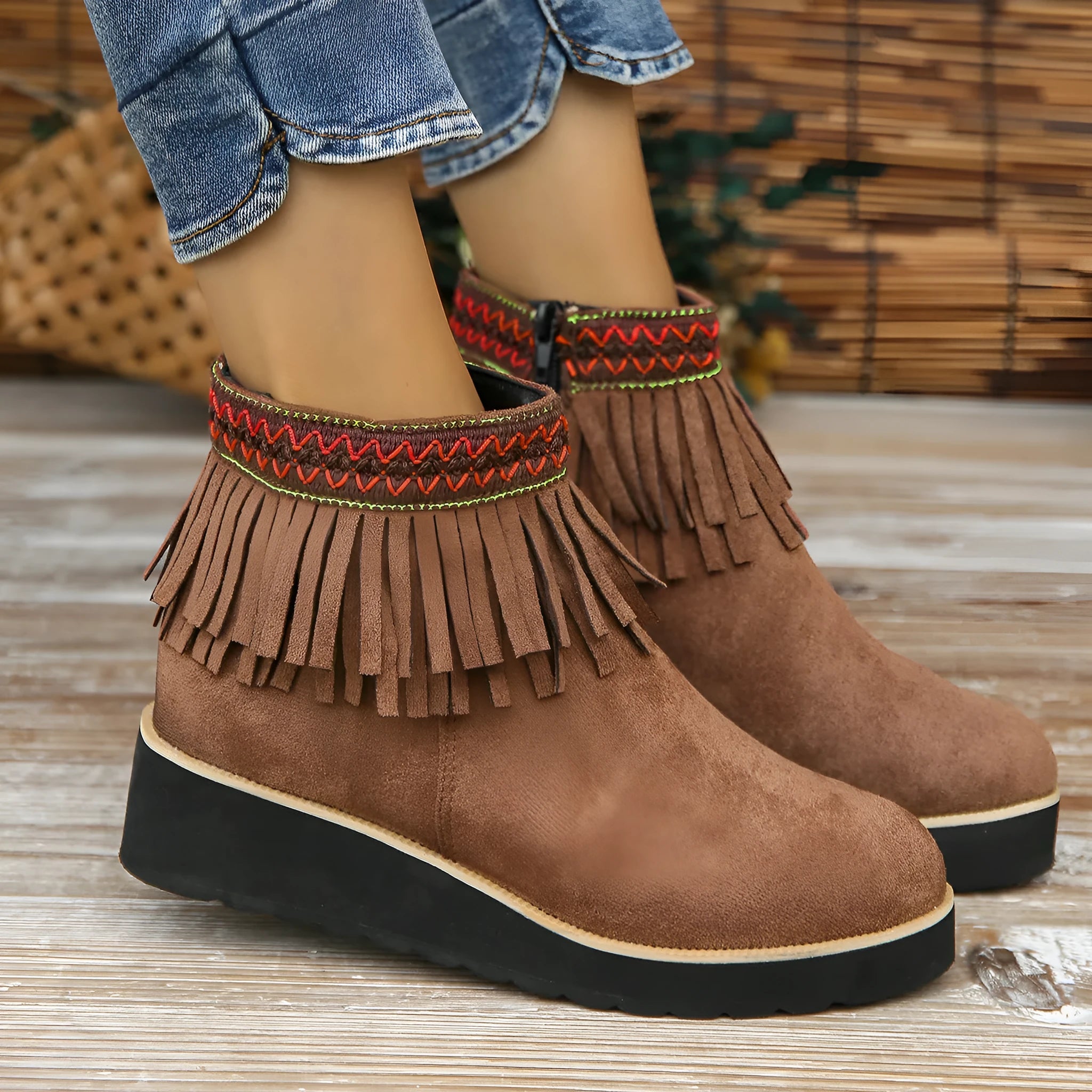 Women's black suede wedge ankle boot with side zip and tassel detail on a thick rubber platform sole.