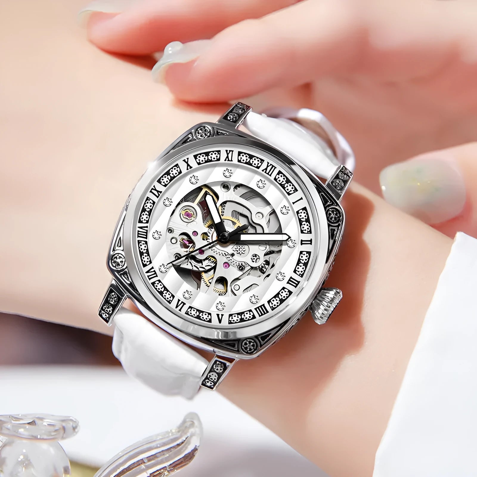 Mechanical watch with luminous hands on a leather strap, showing colour options of black, red, steel, and white dials.