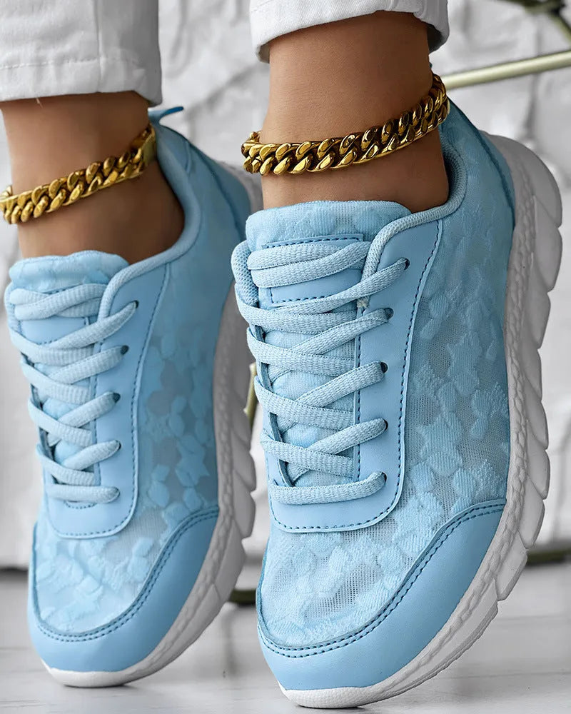 Women's white canvas casual running shoes with flat heel and round toe on a plain background.
