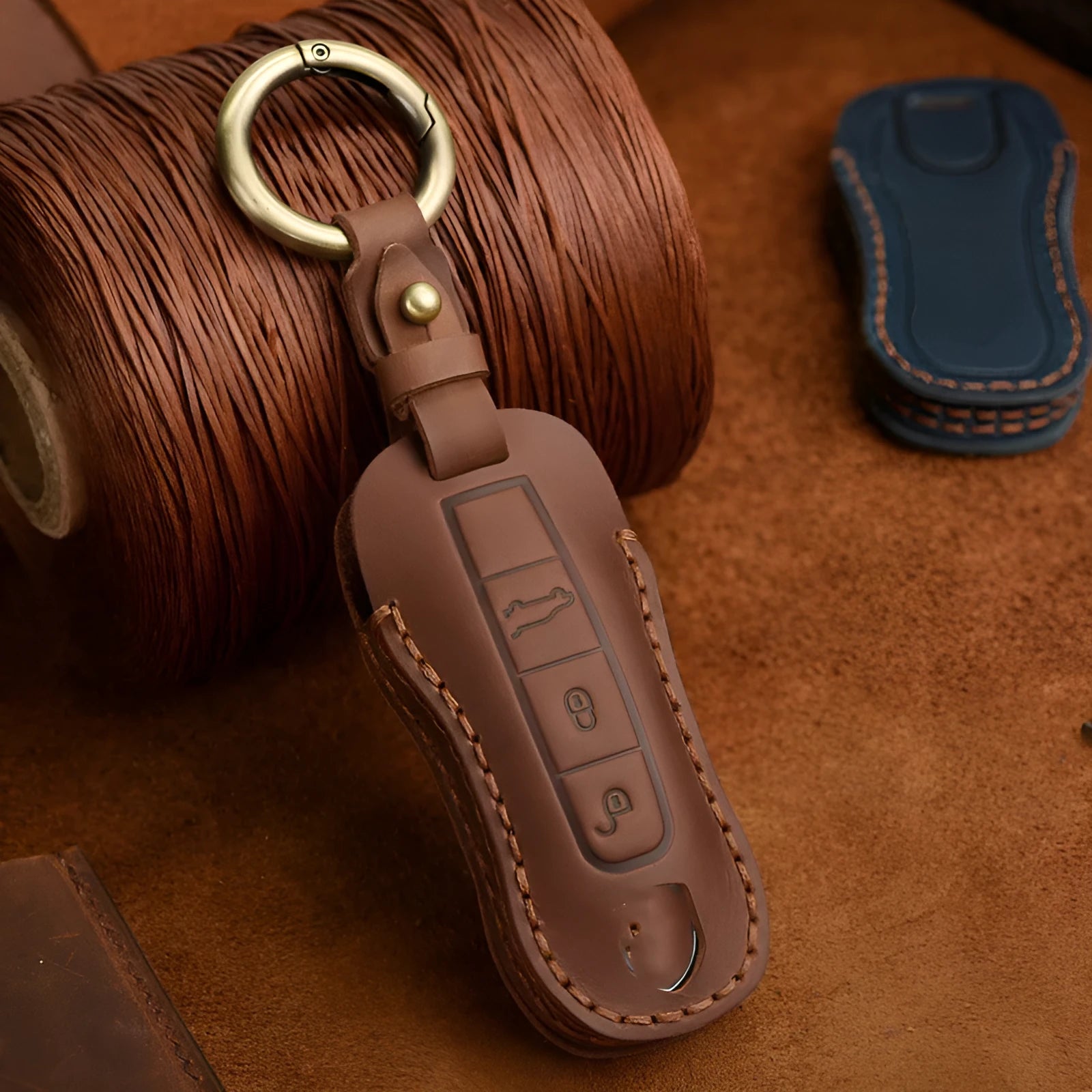Brown leather Porsche key case with retro bag buckle holding three car keys