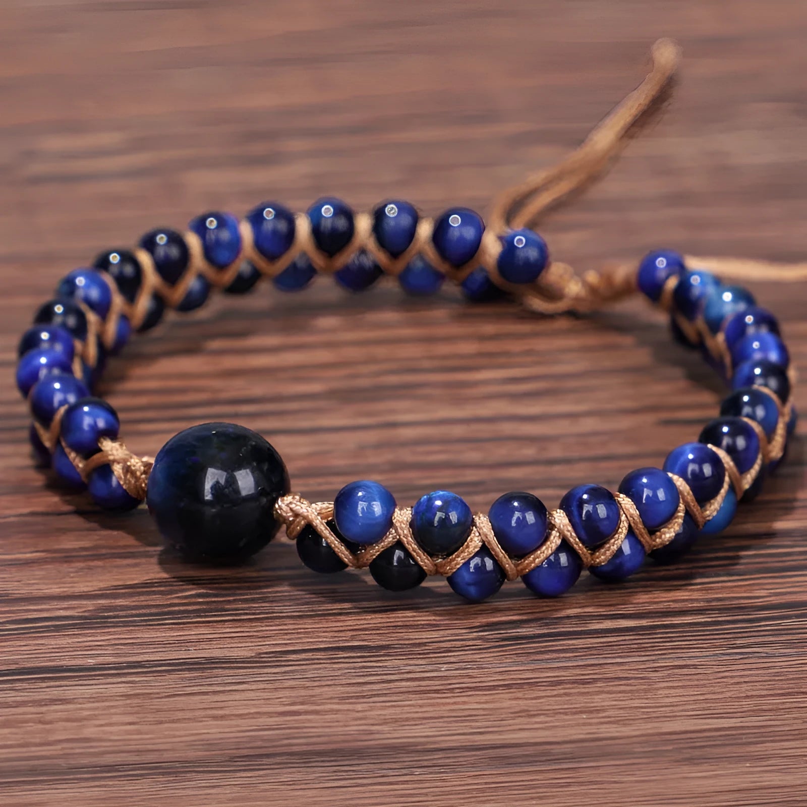 Handmade woven pull bracelet in blue Tigereye or amethyst with geometric design on wrist.