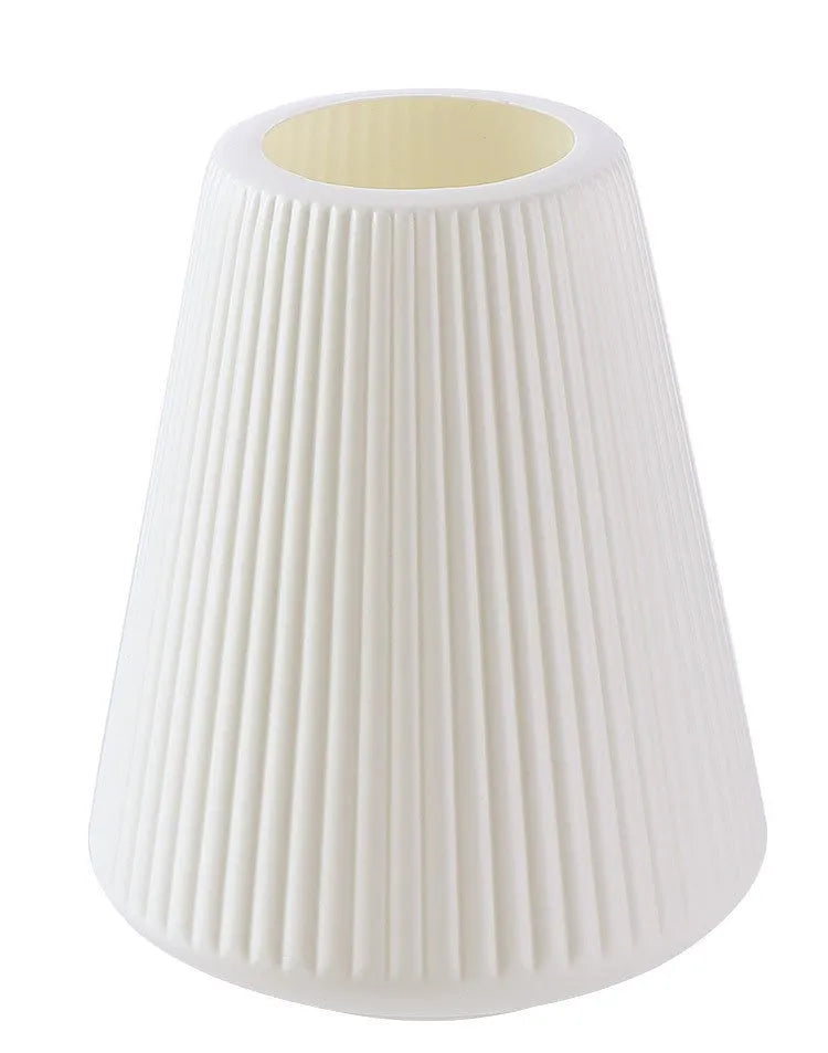 Simple plastic decorative flower vase in blue, green, pink, or white on a desktop.