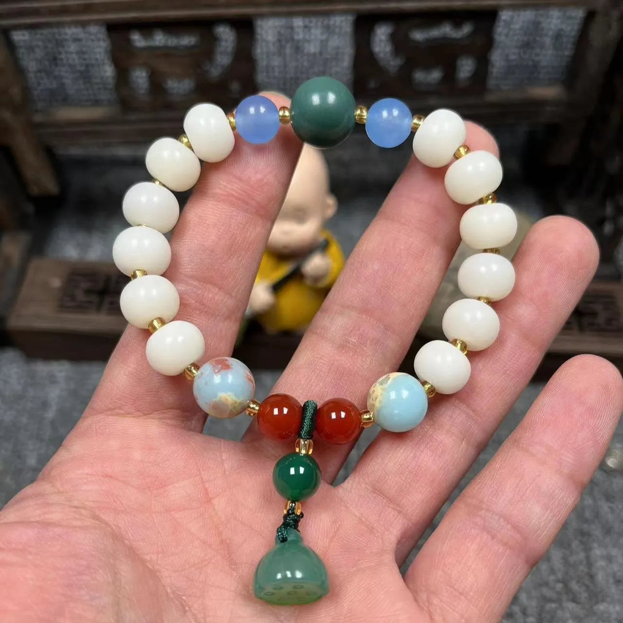 Carved pumpkin and lotus bead bracelet made from Bodhi root with white jade and aventurine details.