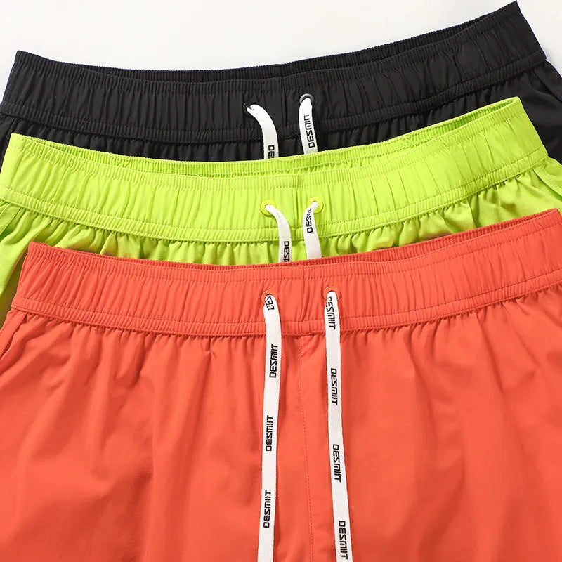 Men's loose fit beach shorts in polyester available in orange red, fluorescent green and black colours