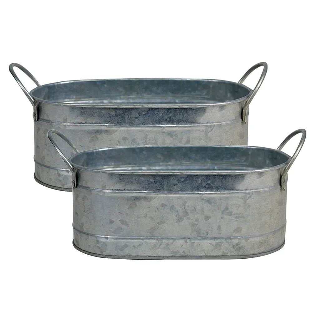 Galvanised iron cylindrical succulent flower pot with a drainage hole on a desk.