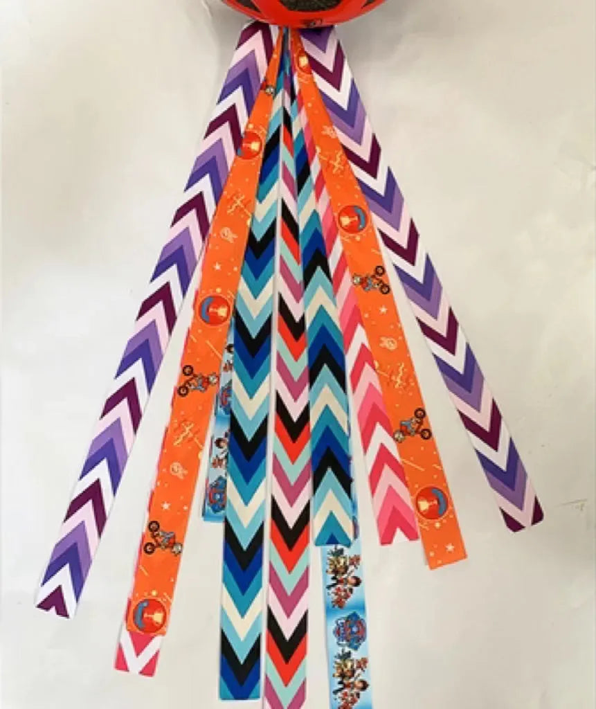 Colourful decorative ribbon streamers attached to a children safety helmet for skating or skiing