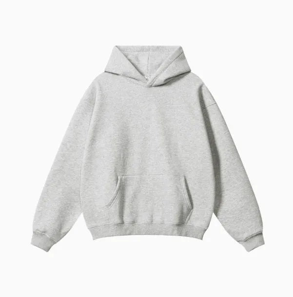 Man wearing a loose grey hooded terry cotton sweater with drop-shoulder sleeves.