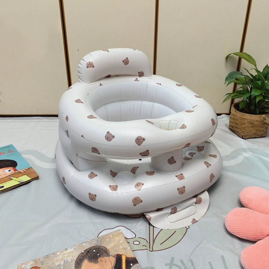 Inflatable infant dining chair in PVC with bear design, deflated beside a baby for scale