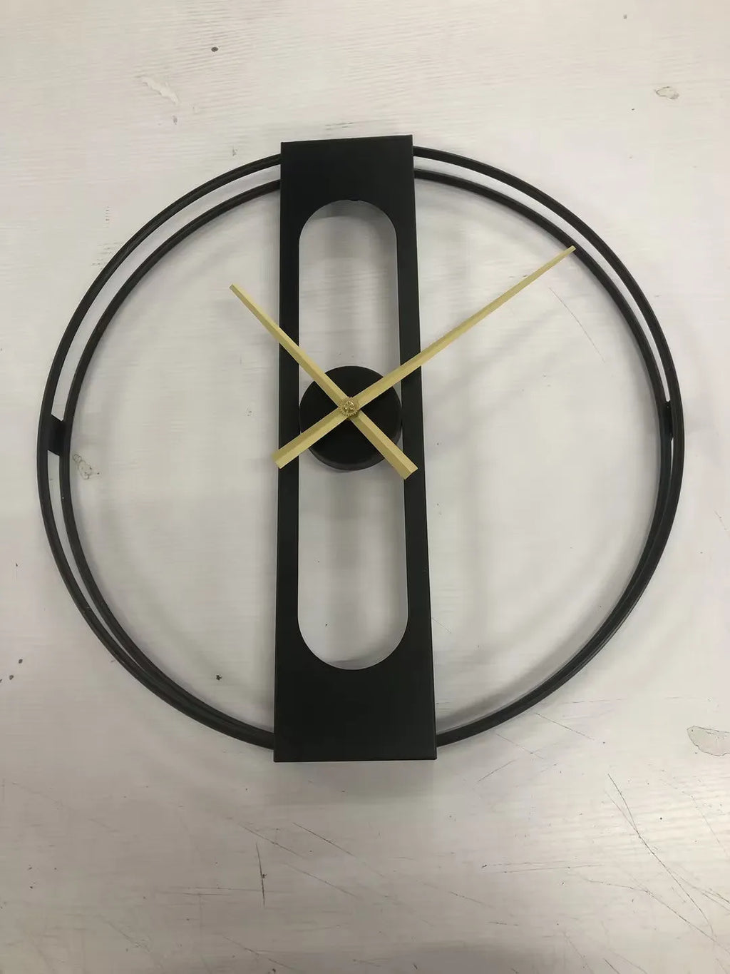 Large round metal wall clock with a 50cm diameter in a black finish on a white wall.