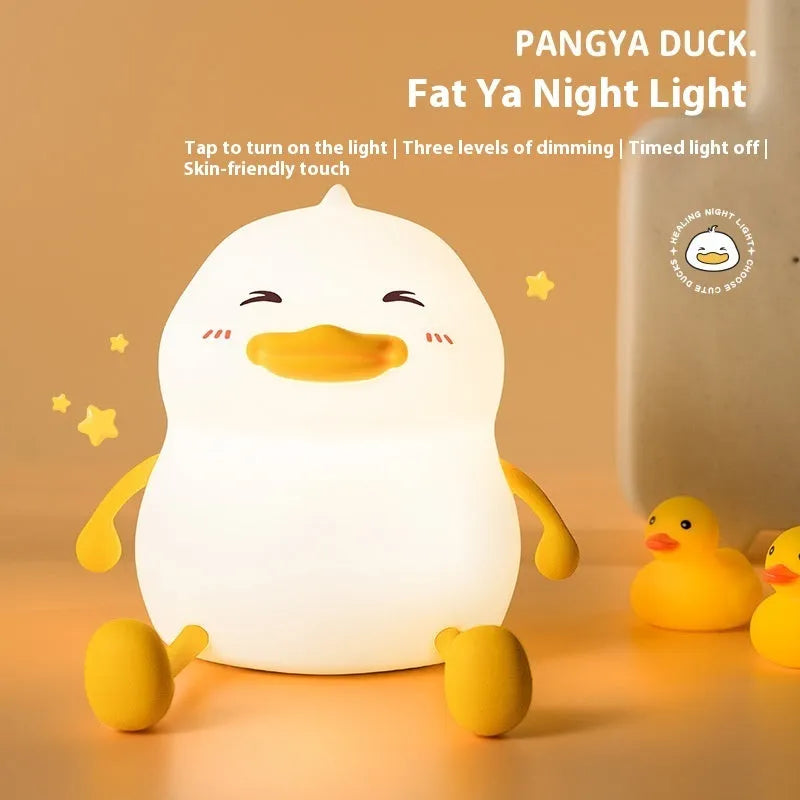 Chubby white silicone rechargeable night light on a wooden desk surface.