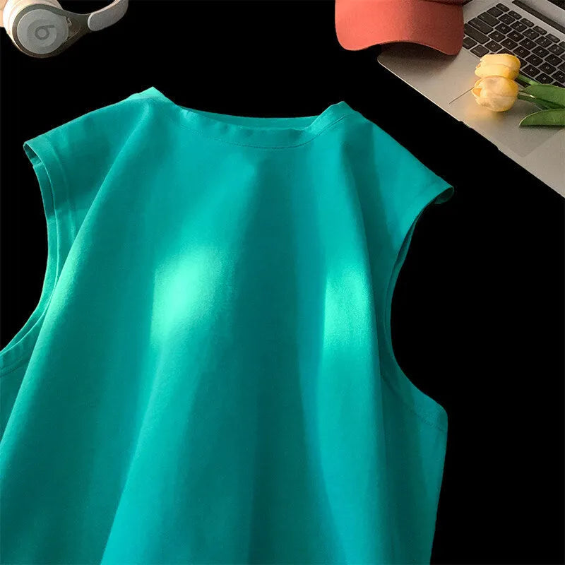 Men's loose solid colour sleeveless cotton tank top on a hanger, shown in a light apricot shade.