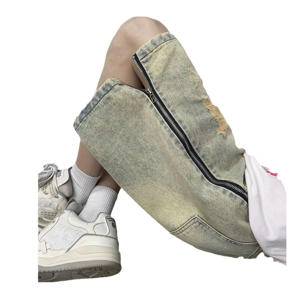 Man wearing blue distressed denim shorts with rips and a loose, straight-leg silhouette.