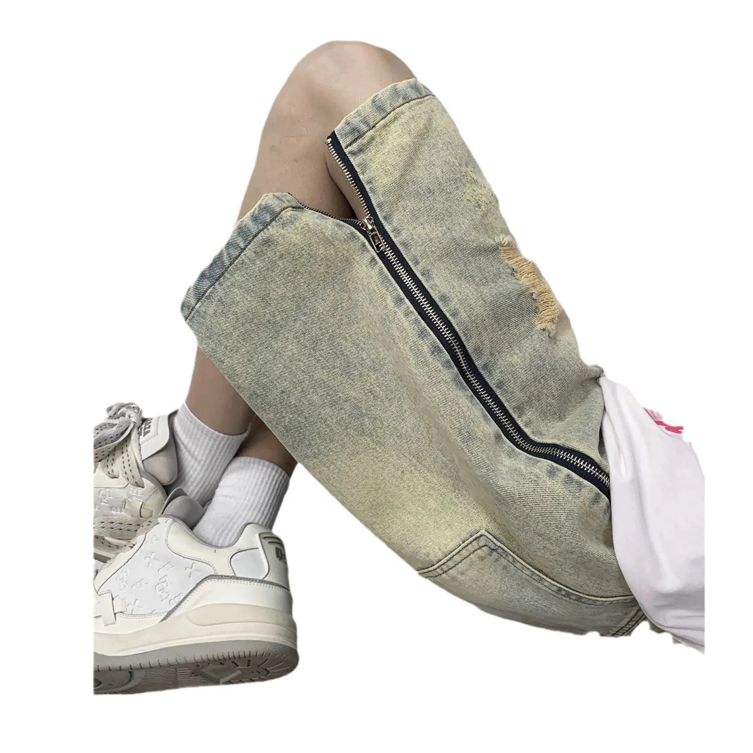 Man wearing blue distressed denim shorts with rips and a loose, straight-leg silhouette.